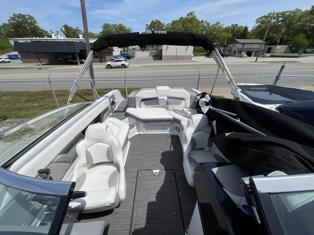 Boat with white seating and canopy at Hall's Sport Center, ideal for water sports and leisure activi.