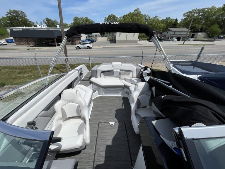 Boat with white seating and canopy at Hall's Sport Center, ideal for water sports and leisure activi.