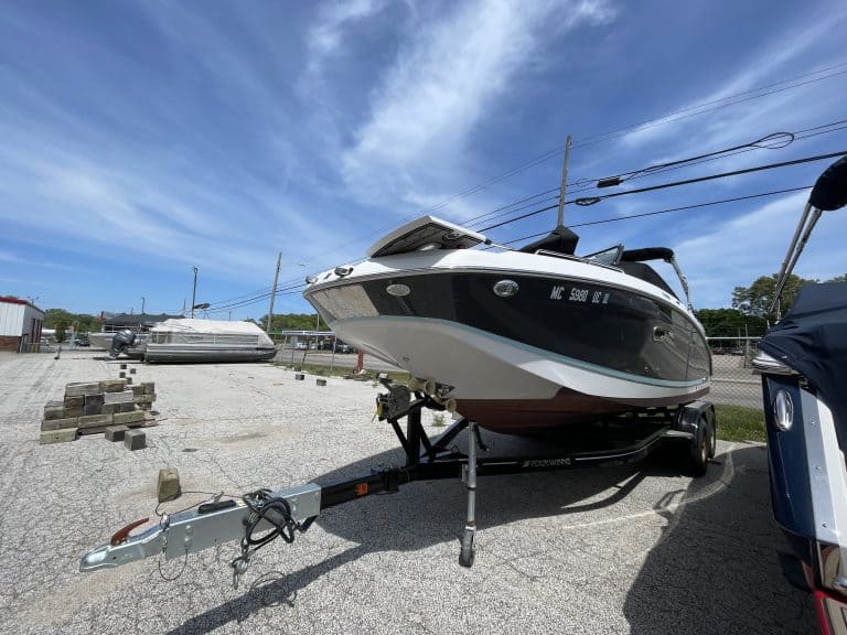 Speedboat on trailer parked outdoors at Hall's Sport Center, ready for water adventures.