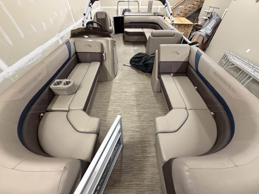 Interior view of a Bennington 21SXL pontoon boat with seating and steering console.