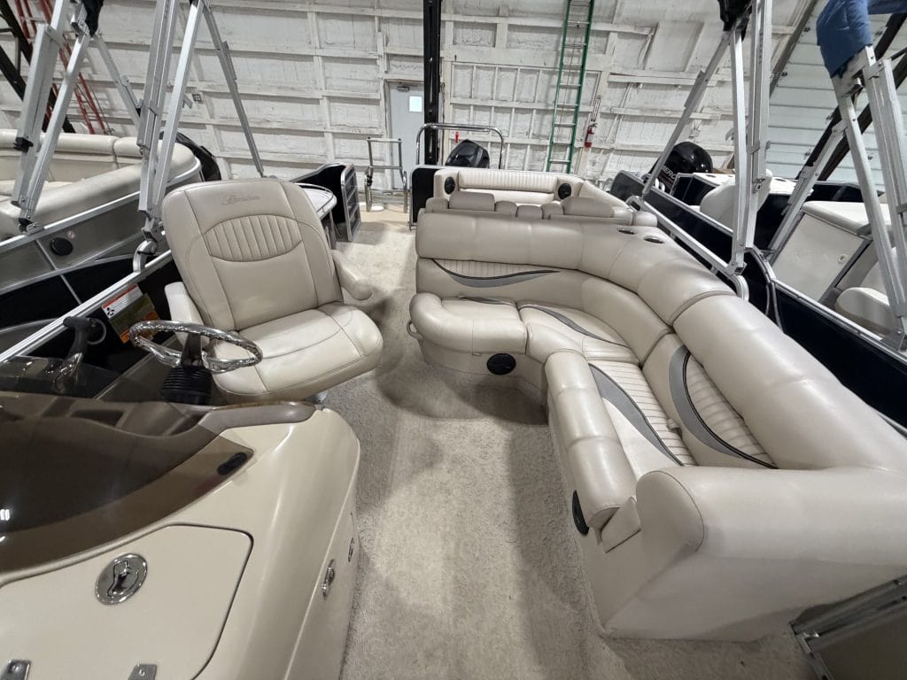 Luxury boat interior with beige seating and steering wheel at Hall's Sport Center.