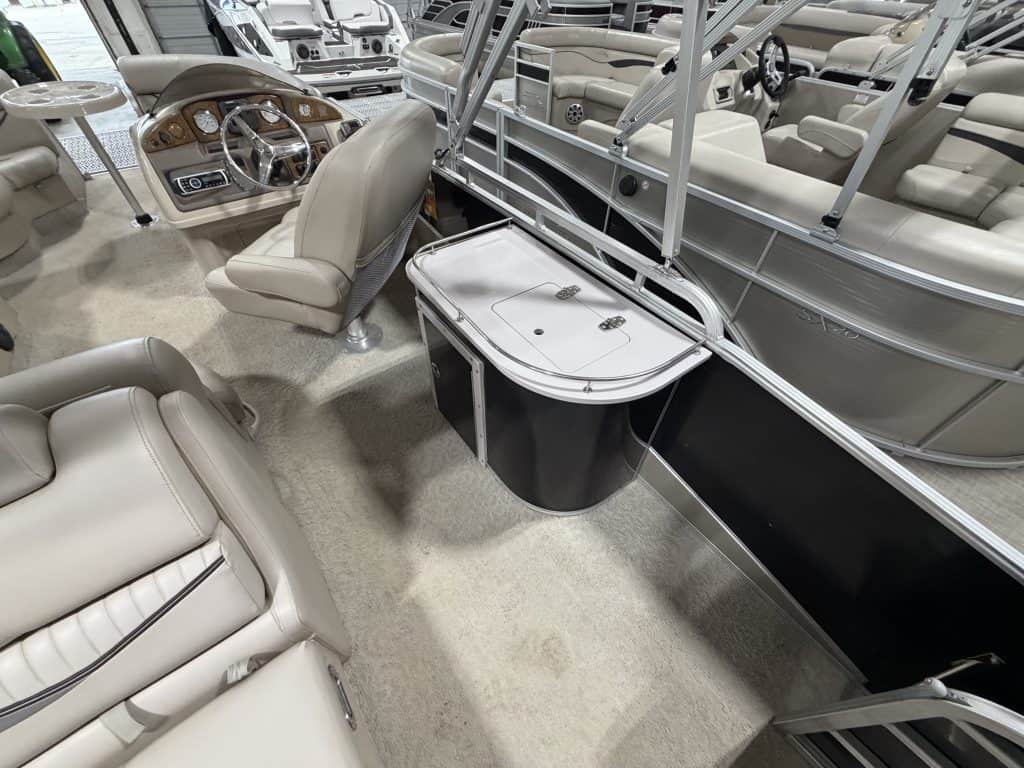 Luxury pontoon boat interior with seating and steering console at Hall's Sport Center.