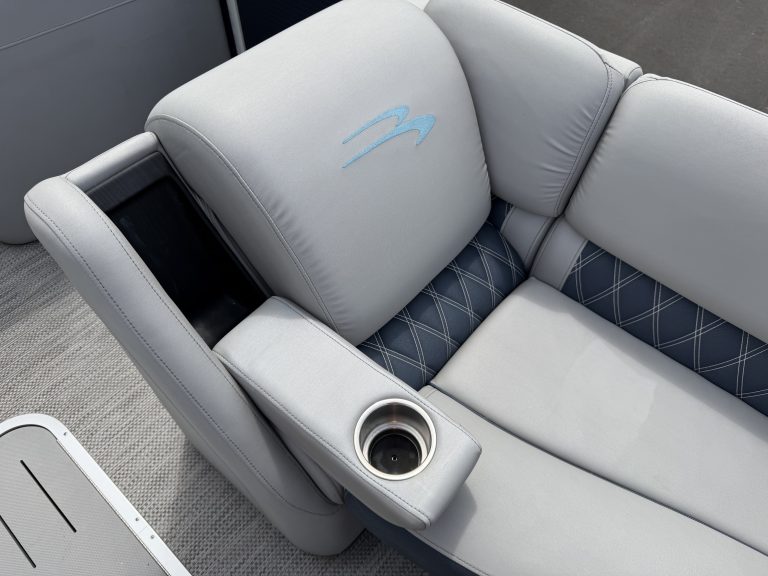 Luxury pontoon boat seat with cup holder and plush cushions.