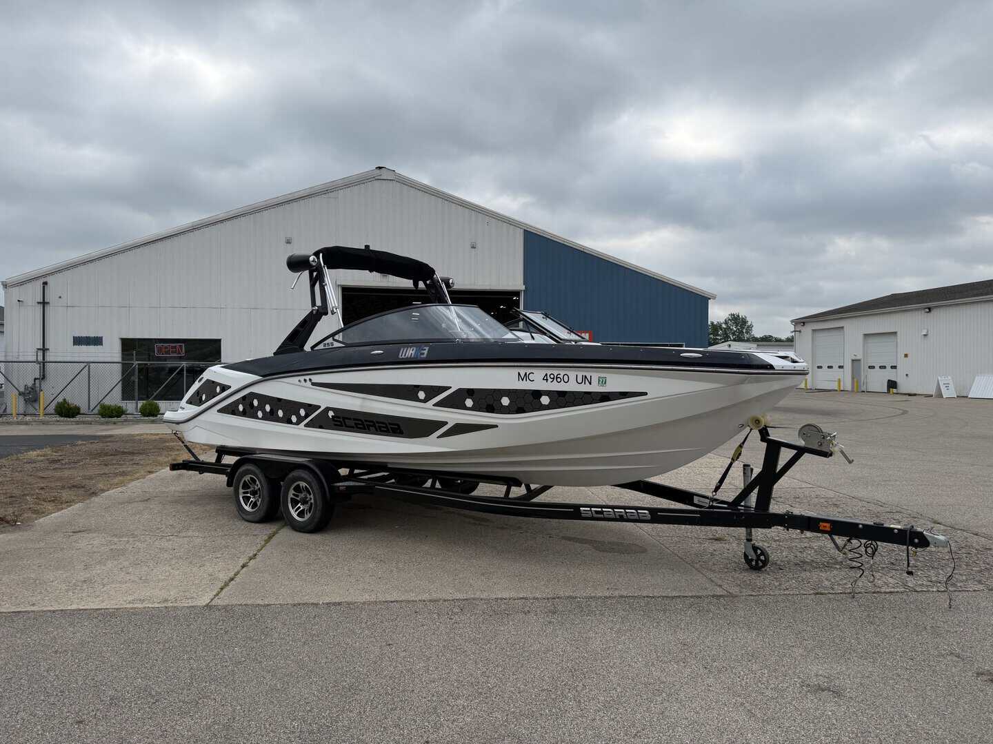 Luxury 2021 Scarab 255ID powerboat on trailer at marina.