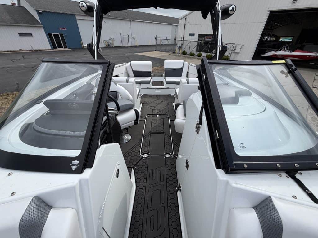 Interior view of a white boat at Hall's Sport Center with seating and steering area.