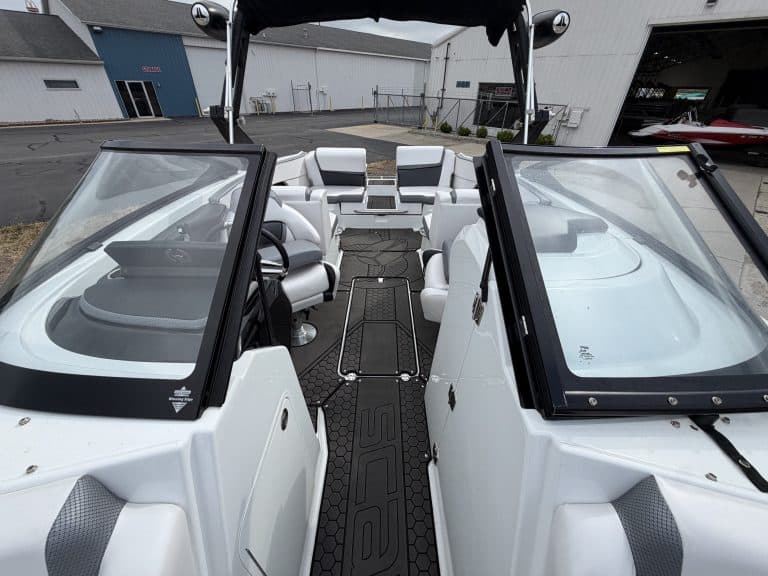 Interior view of a white boat at Hall's Sport Center with seating and steering area.