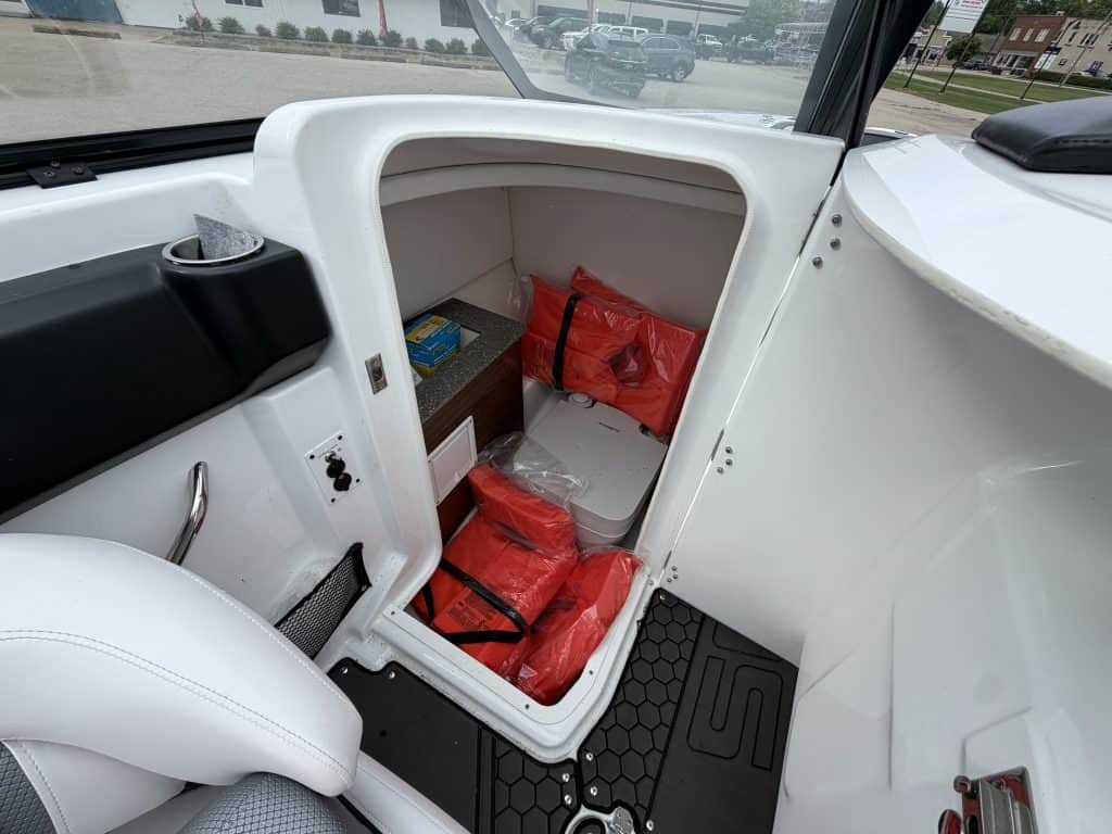 Storage compartment of a 2021 Scarab 255ID boat with red safety gear inside.