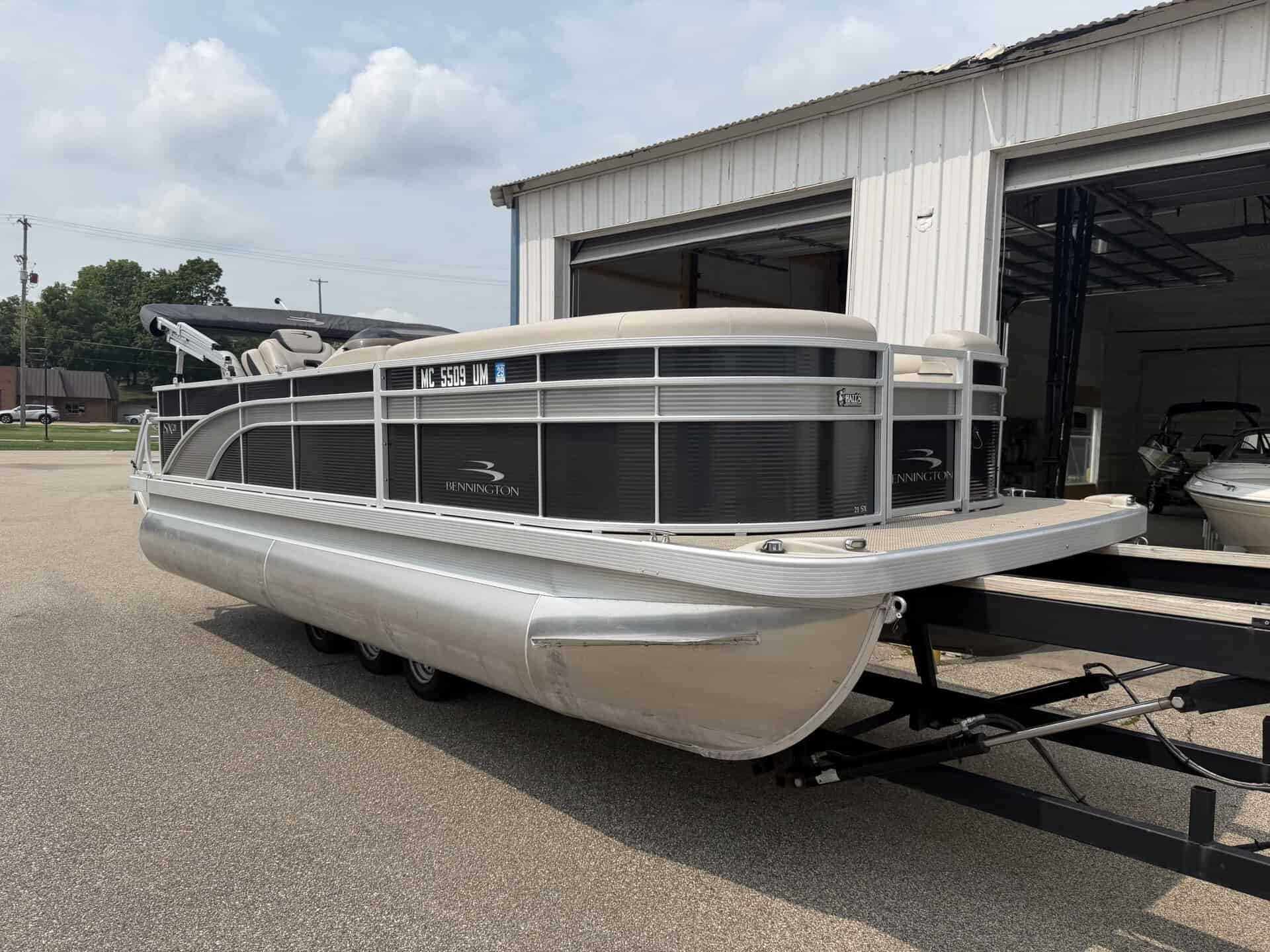 Bennington 21 SS pontoon boat parked outside a building.