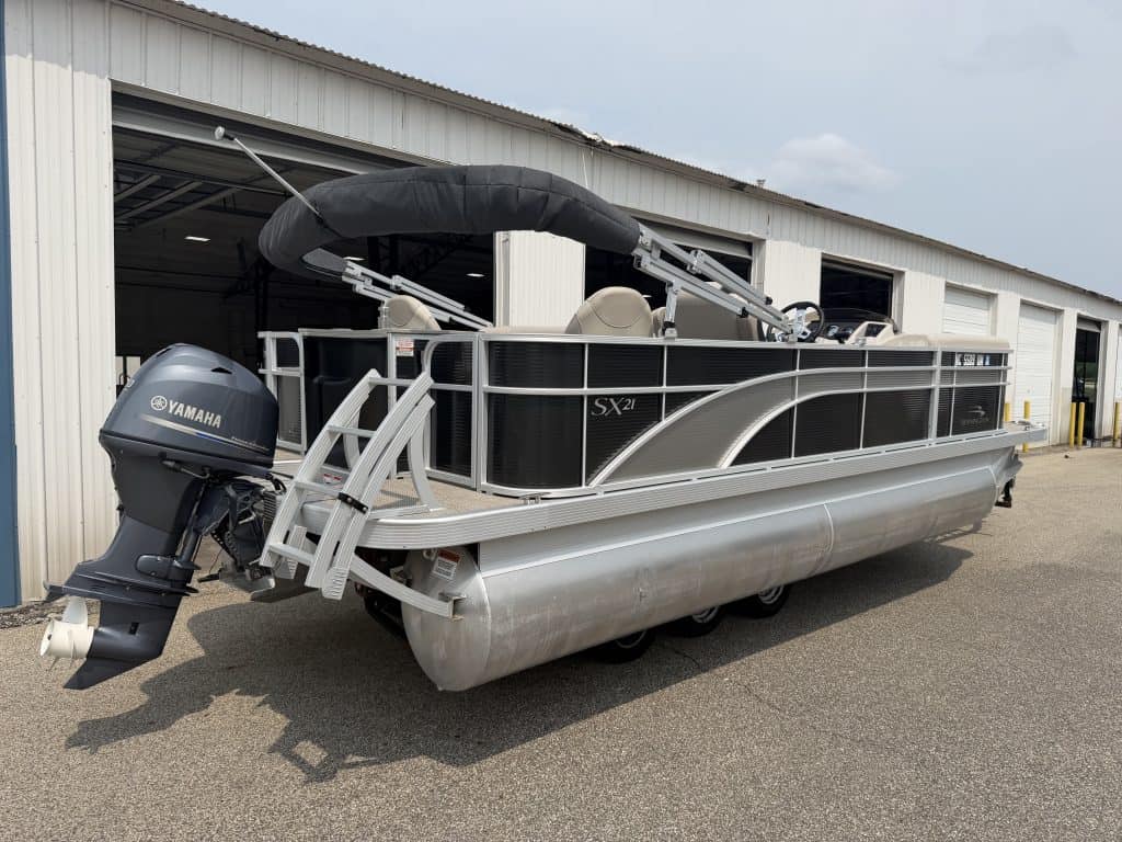 Bennington 21 SS pontoon boat with Yamaha engine outside a storage building.