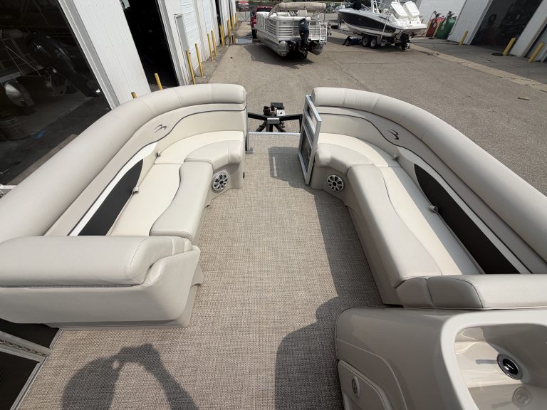 Comfortable white pontoon boat seating with a central table for socializing.