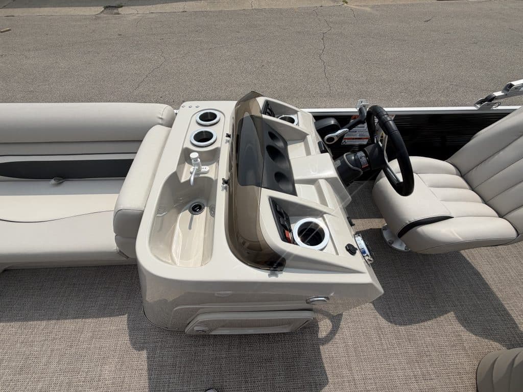 Pontoon boat dashboard with steering wheel and controls at Hall's Sport Center.