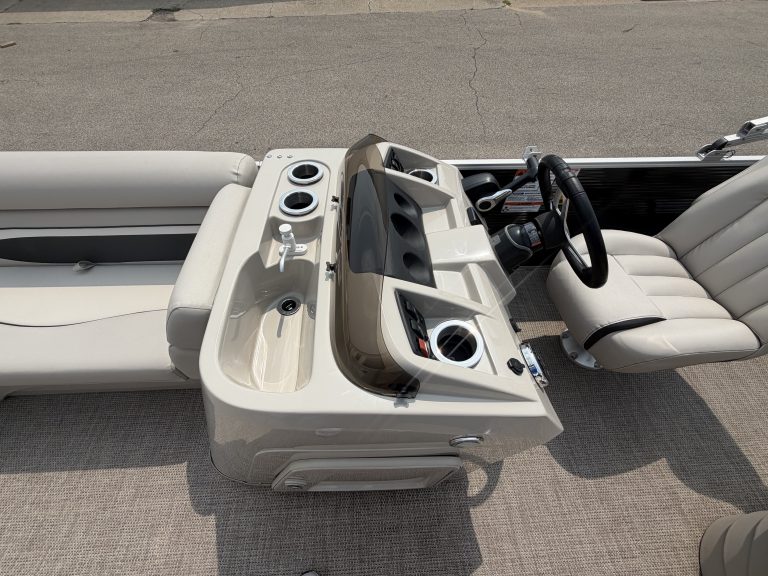 Pontoon boat dashboard with steering wheel and controls at Hall's Sport Center.