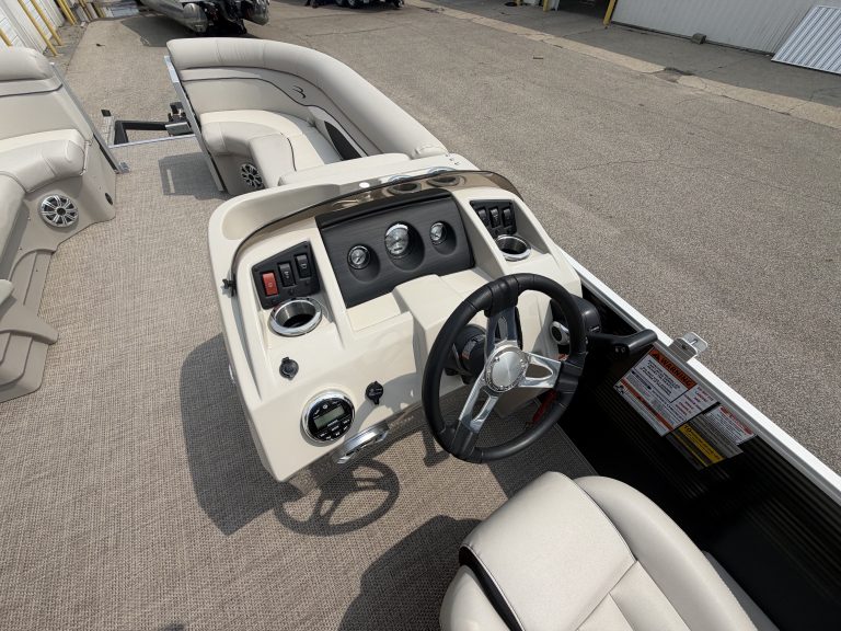 Pontoon boat dashboard with steering wheel and controls at Hall's Sport Center.