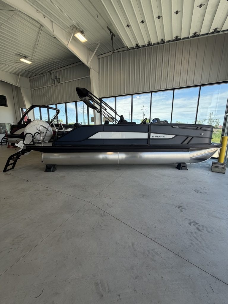 Luxury pontoon boat displayed at Hall's Sport Center with large windows in the background.