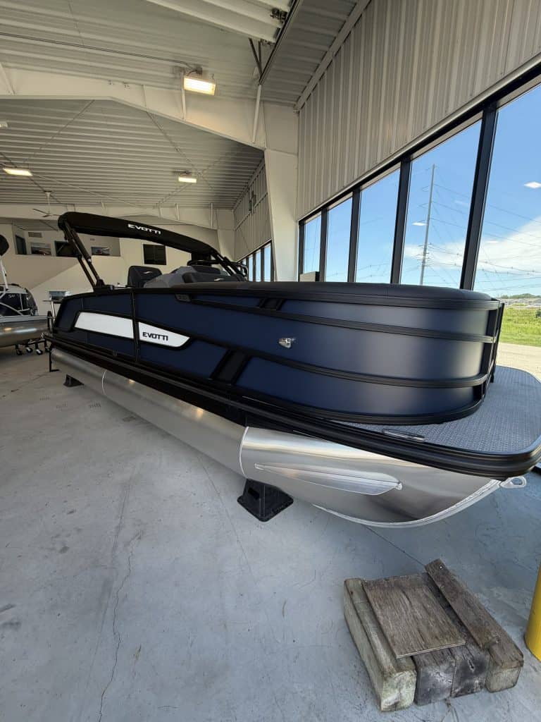 Luxury pontoon boat displayed at Hall's Sport Center with large windows and bright interior.