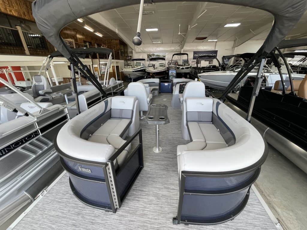 Modern pontoon boat showroom at Hall's Sport Center with various boats on display.