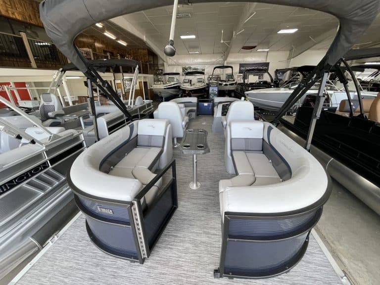 Modern pontoon boat showroom at Hall's Sport Center with various boats on display.
