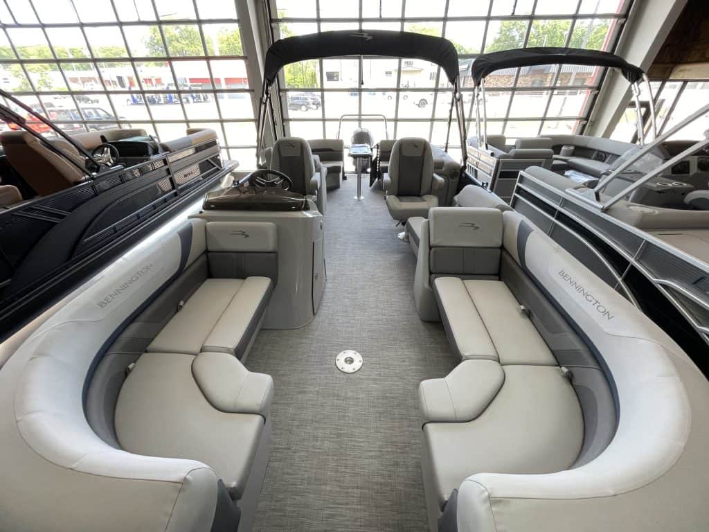 Luxury pontoon boat interior with seating and navigation controls at Hall's Sport Center.