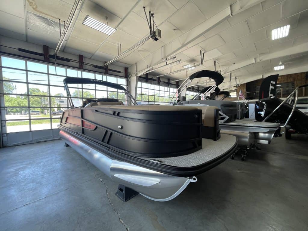 Luxury pontoon boat inside Hall's Sport Center showroom.