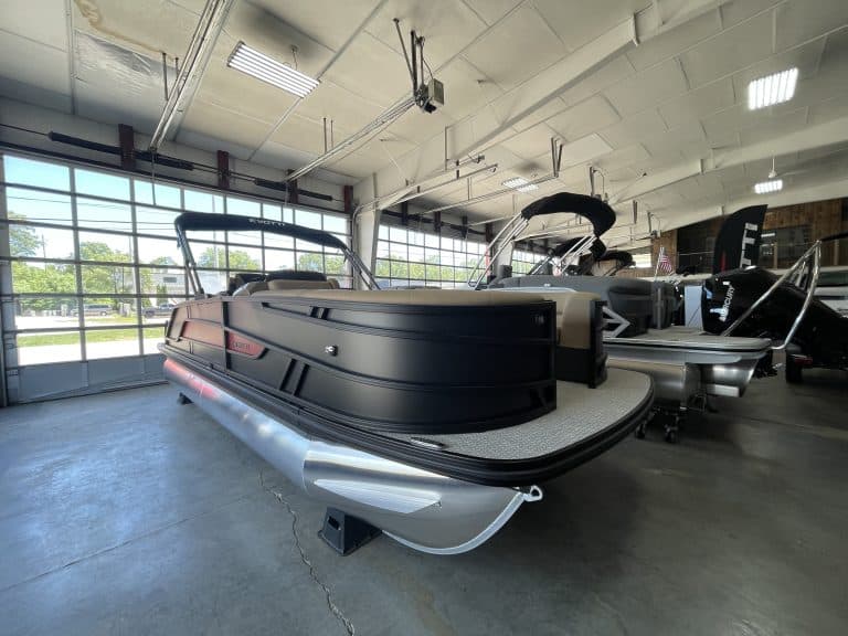 Luxury pontoon boat inside Hall's Sport Center showroom.
