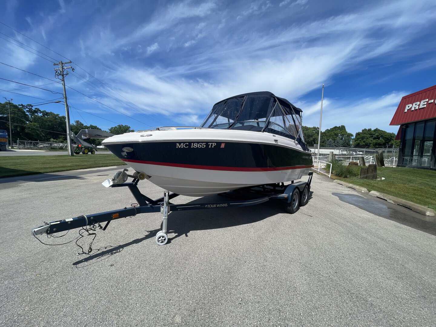 Four Winns 215 SUNDOWNER boat on trailer at Hall's Sport Center.