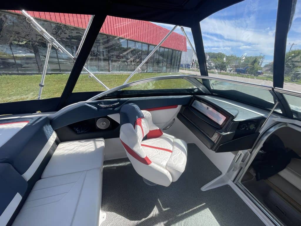 View of boat cockpit with steering wheel and seating at Hall's Sport Center.