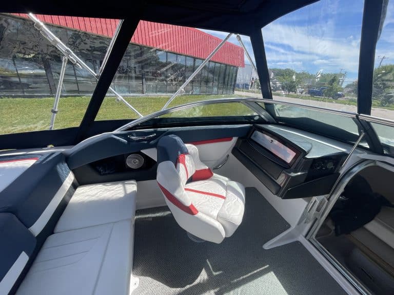 View of boat cockpit with steering wheel and seating at Hall's Sport Center.