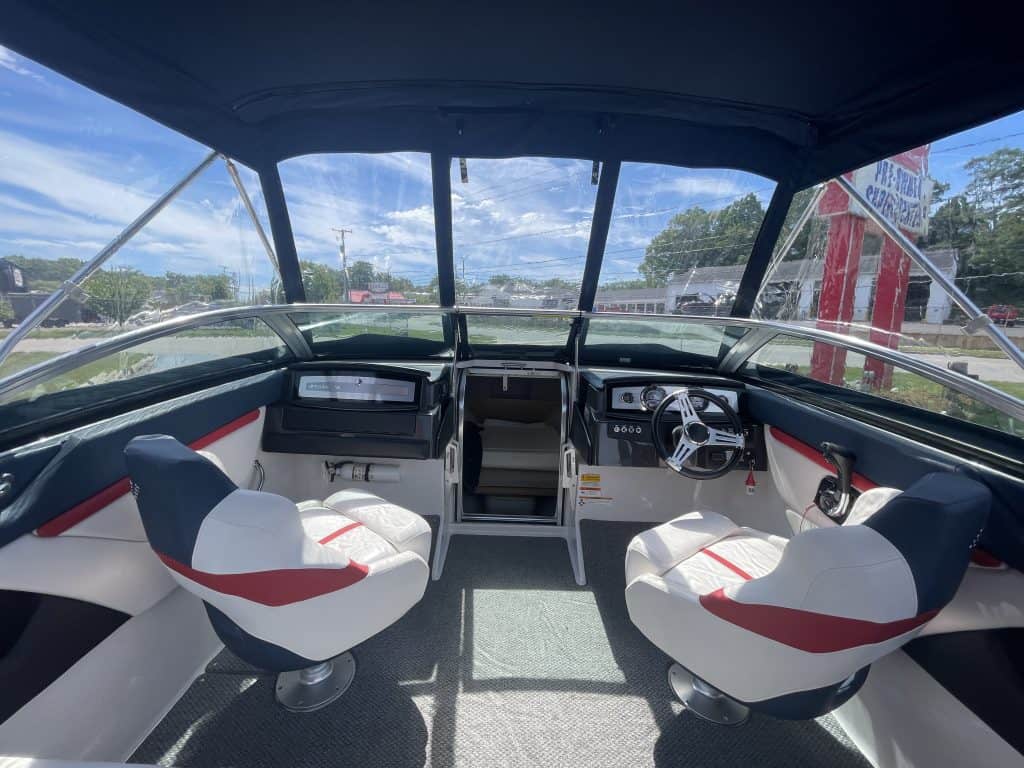 View of boat cockpit with steering wheel and seats at Hall's Sport Center.