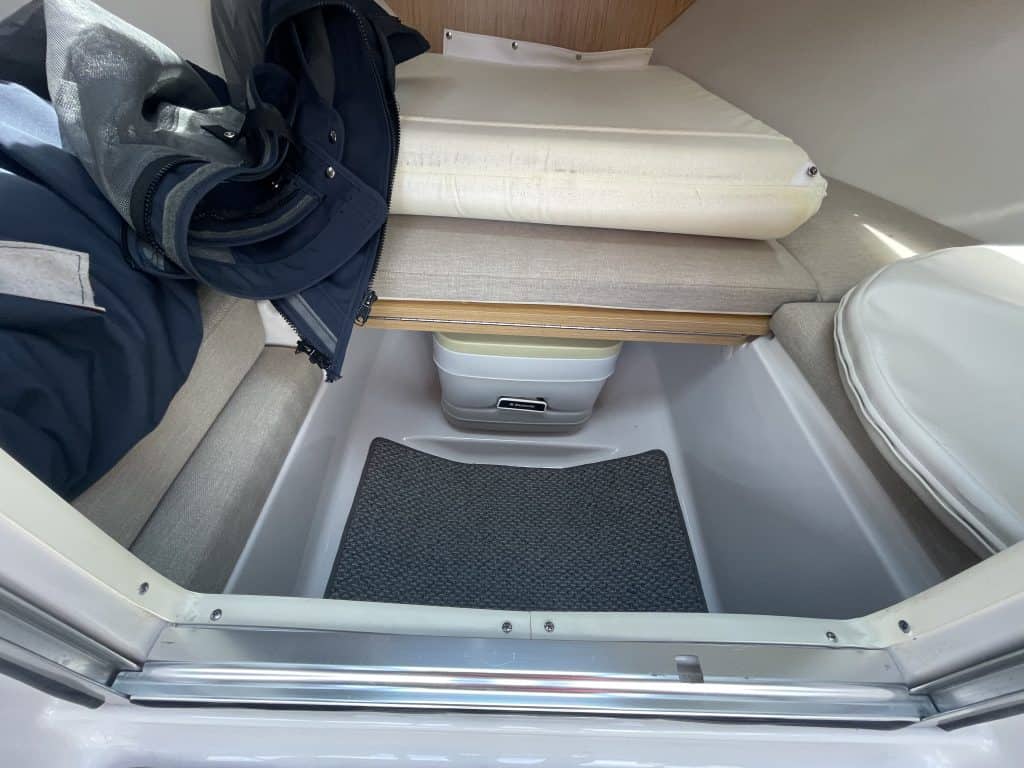 Boat storage compartment with gear and cushion at Hall's Sport Center.