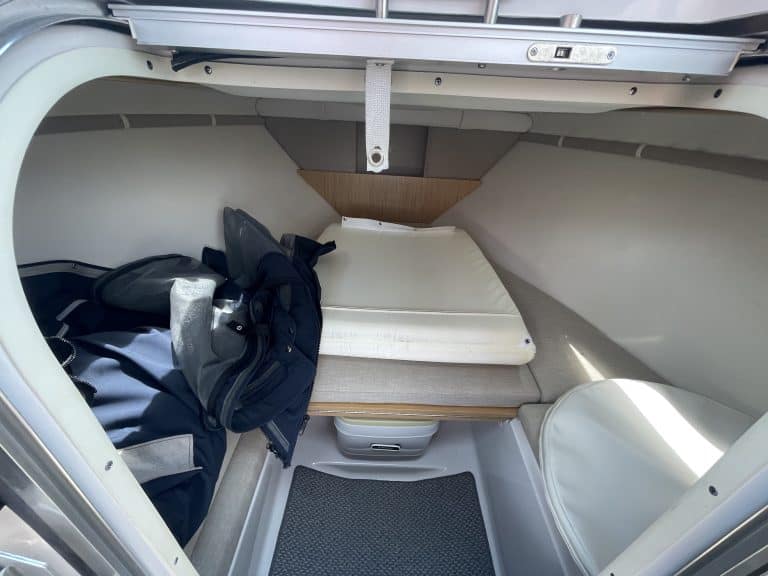 Interior of a 2013 Four Winns 215 SUNDOWNER boat with sleeping area and storage.