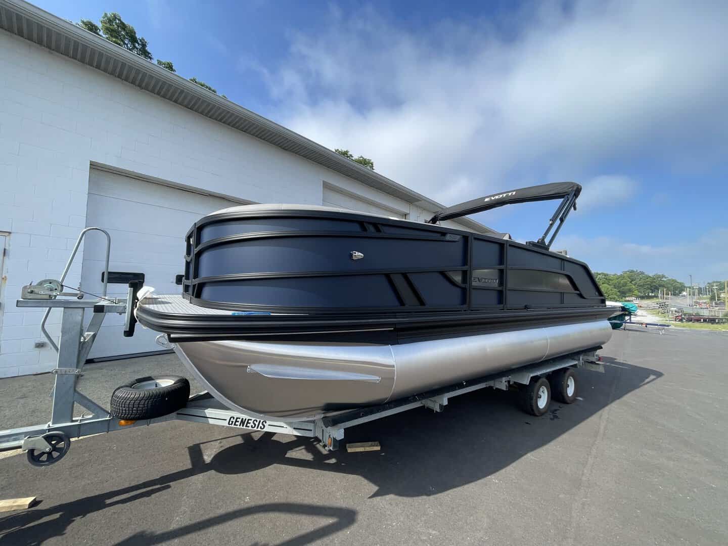 Luxury pontoon boat at Hall's Sport Center with sleek black design.