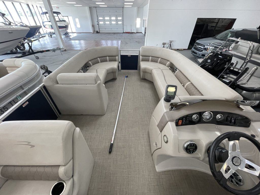 Interior view of a Bennington 21 SLX pontoon boat with seating and steering wheel.
