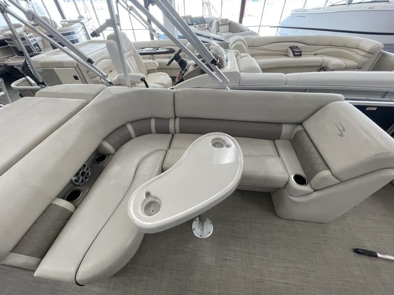 Luxury pontoon boat interior with seating and a built-in table.