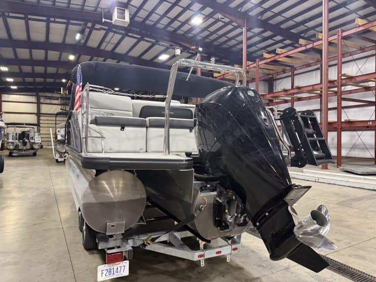 Harris 230 SBHL pontoon boat with outboard motor inside warehouse.