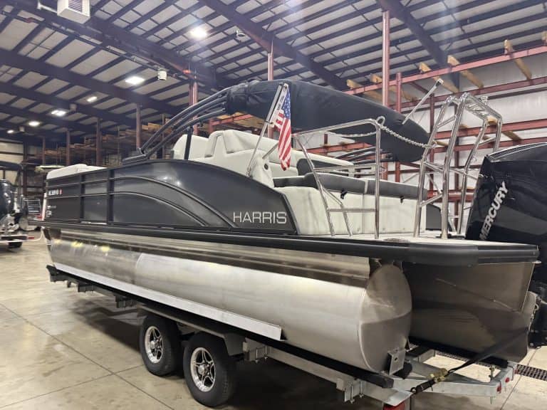 Harris 230 SBHL pontoon boat inside a warehouse on a trailer.