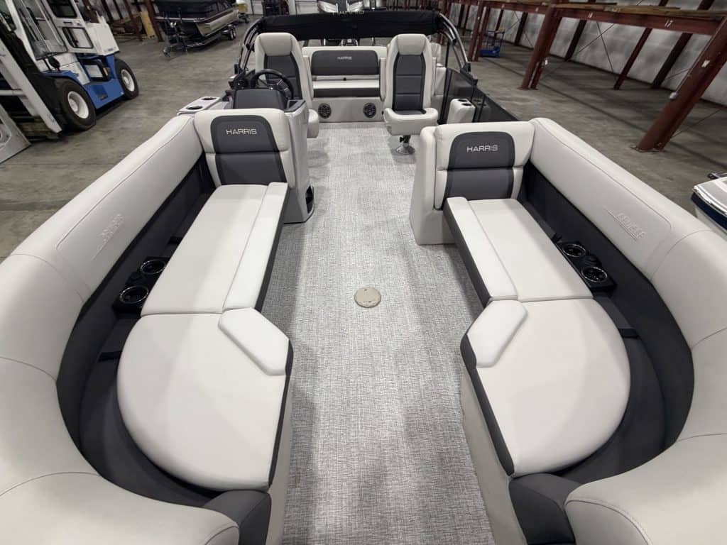 Interior view of Harris 230 SBHL pontoon boat with seating and steering console.