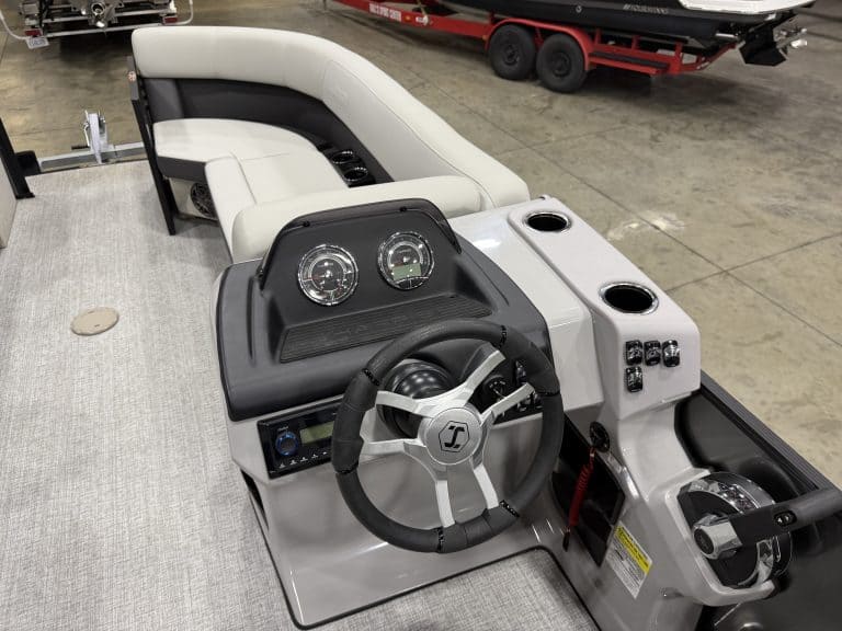 Boat control console with steering wheel and gauges at Hall's Sport Center.