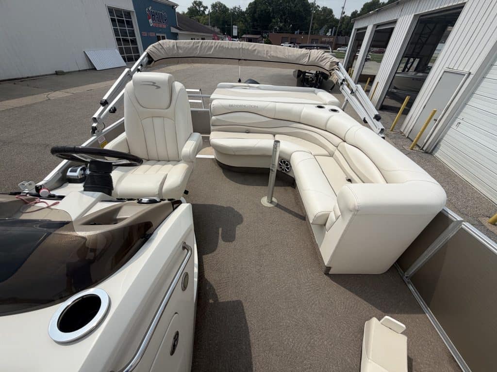 Luxury pontoon boat with white seating and canopy for leisure boating.