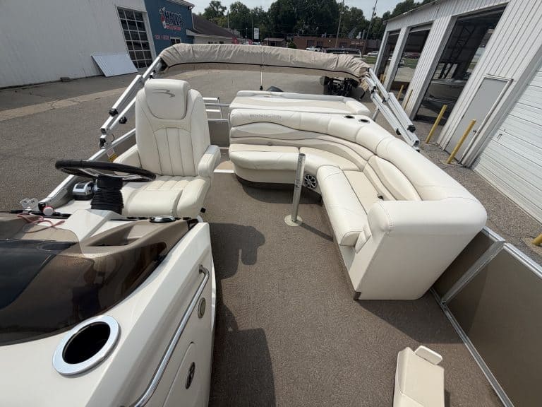 Luxury pontoon boat with white seating and canopy for leisure boating.
