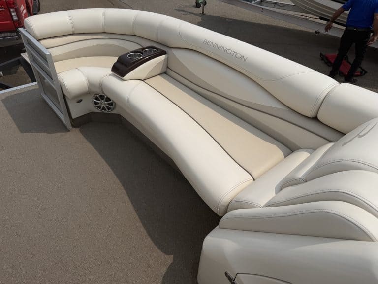 Luxury white pontoon boat seating with built-in speakers and cup holders.