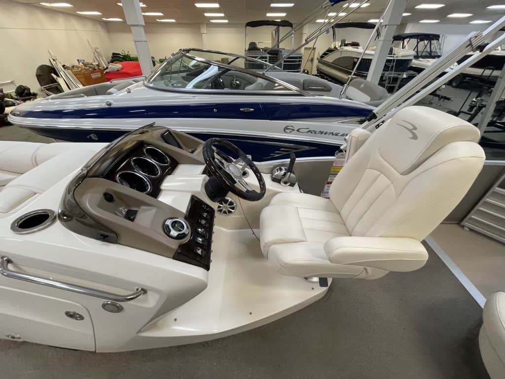 Luxury pontoon boat interior with captain's chair and dashboard.