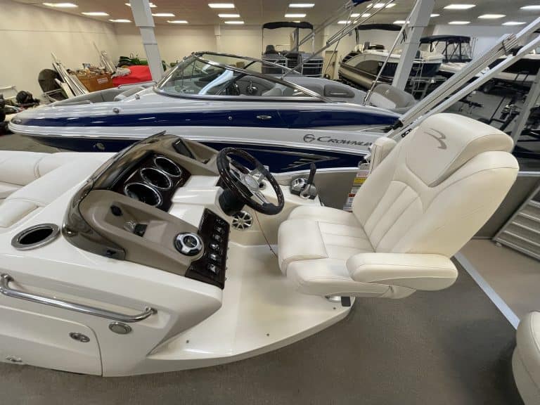 Luxury pontoon boat interior with captain's chair and dashboard.