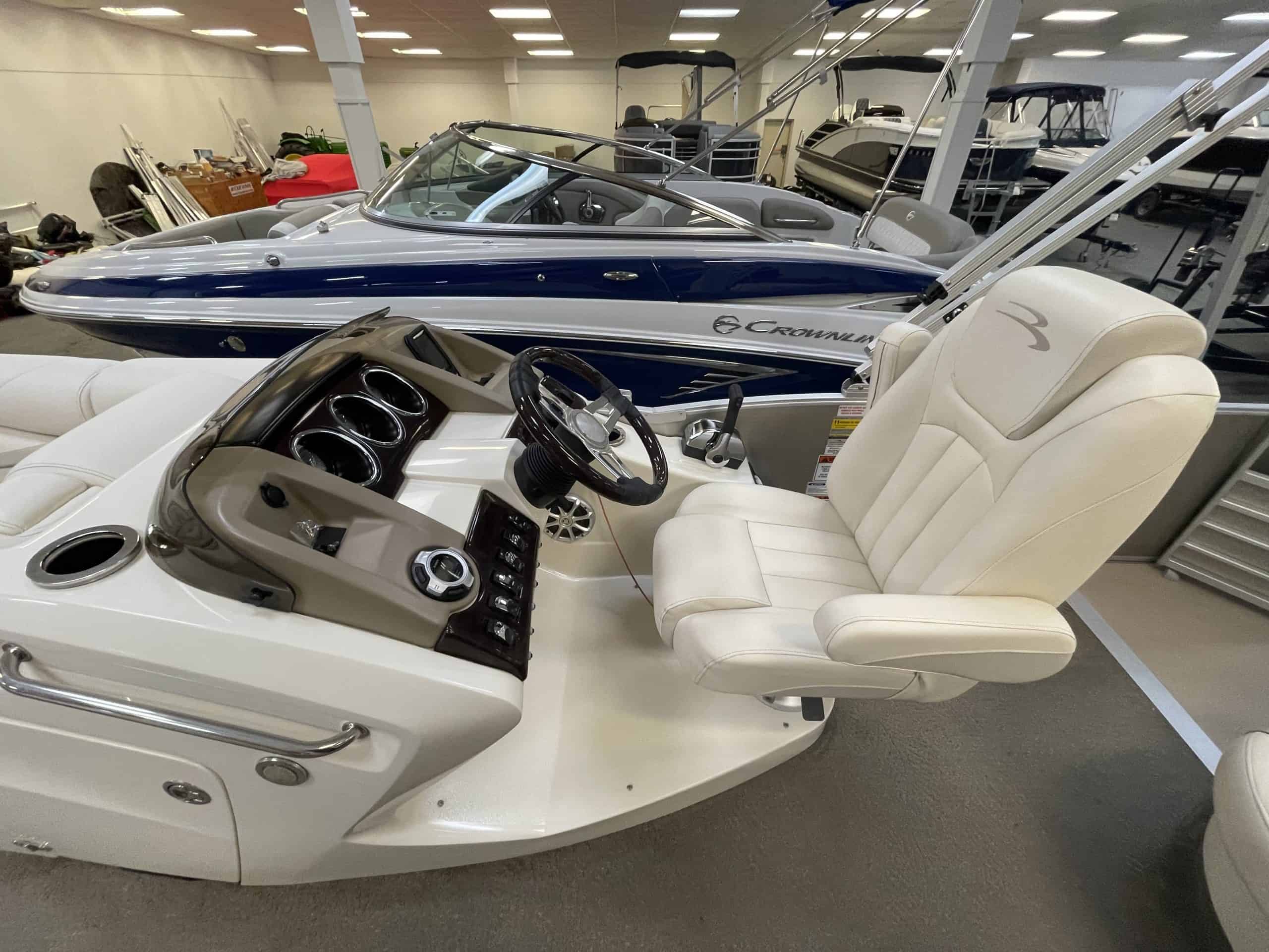 Luxury pontoon boat interior with captain's chair and dashboard.