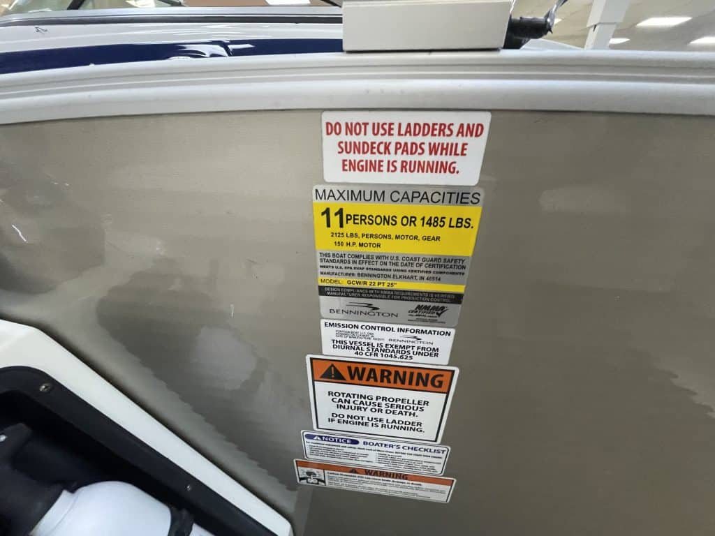 Boat safety and capacity labels on the side of a boat.