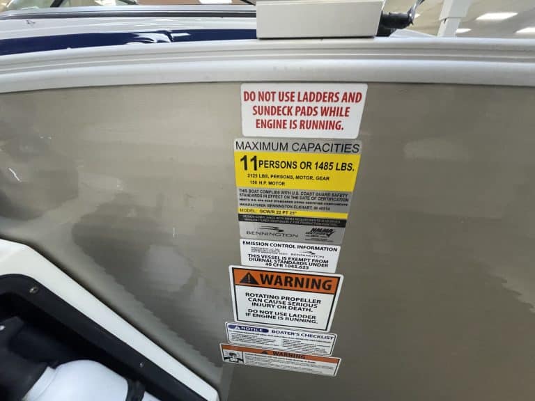 Boat safety and capacity labels on the side of a boat.