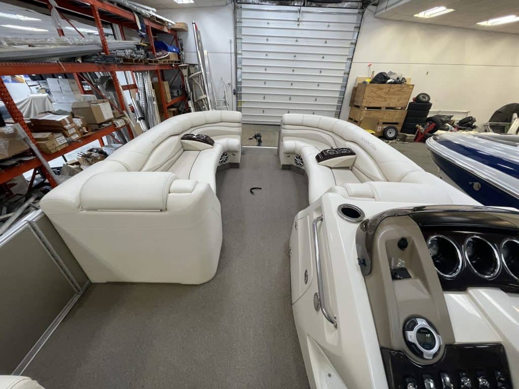 Luxury Bennington 2275 RL pontoon boat with white seating in storage.