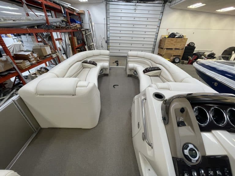 Luxury Bennington 2275 RL pontoon boat with white seating in storage.