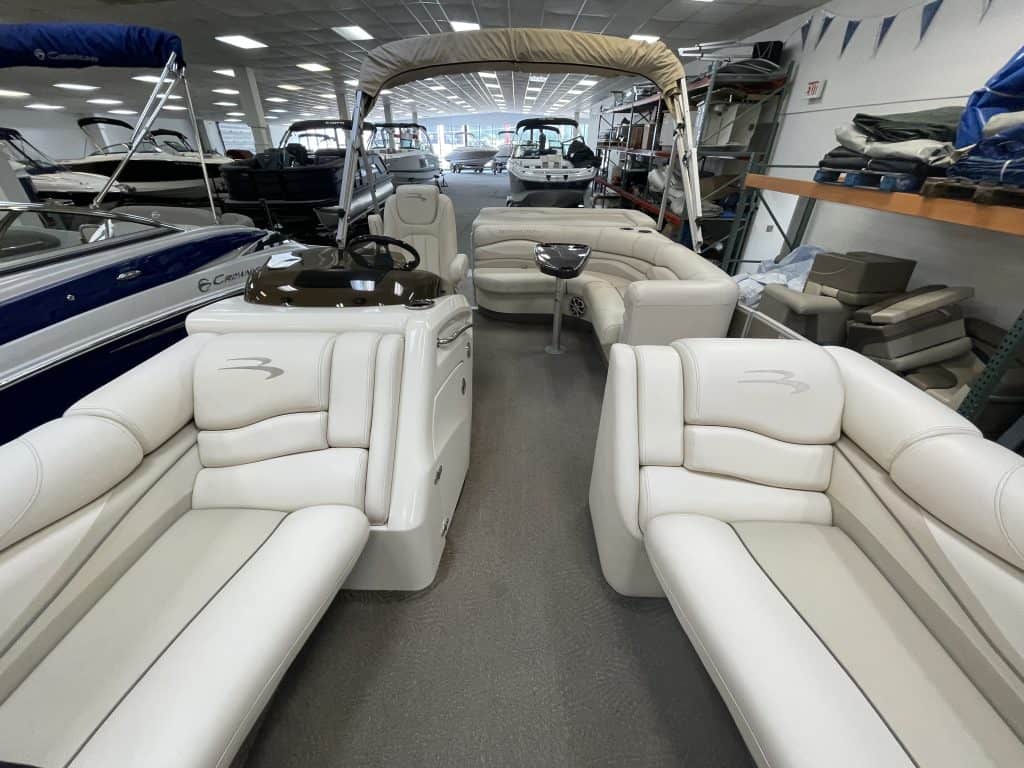 Luxury pontoon boat interior with white seating and helm station.