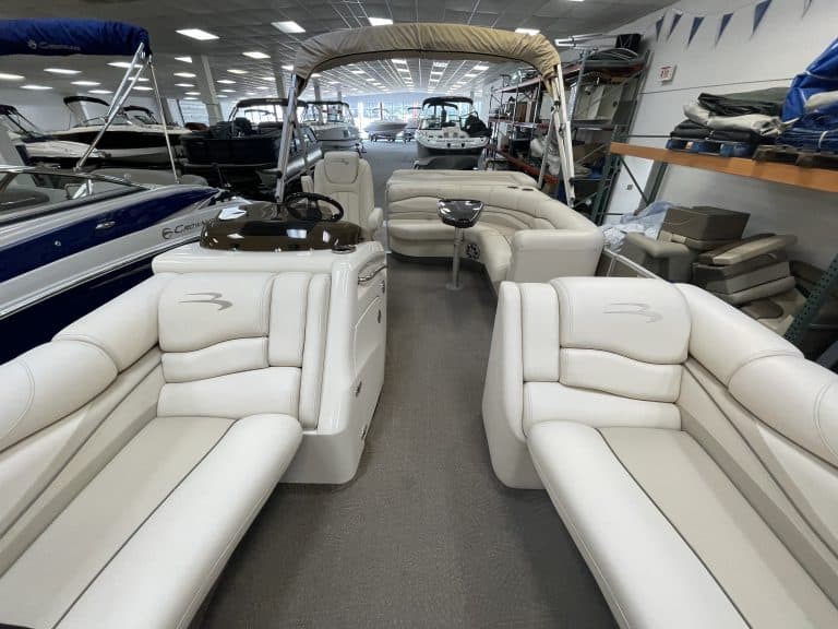 Luxury pontoon boat interior with white seating and helm station.