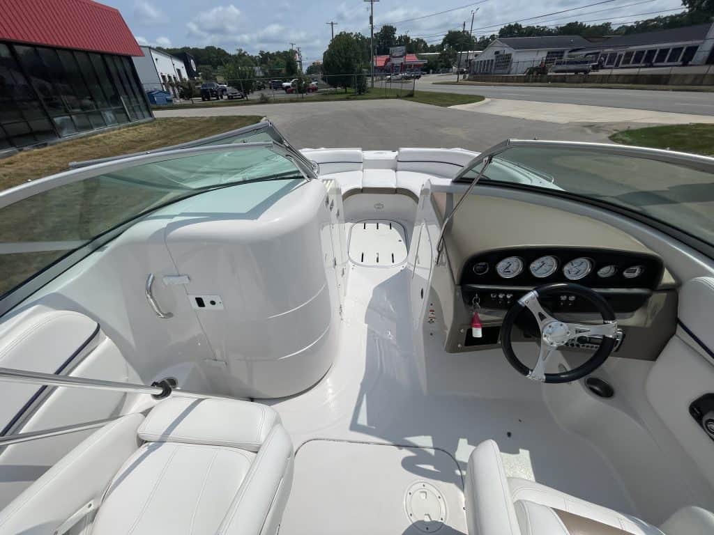 View of the boat's interior with white seating and dashboard.